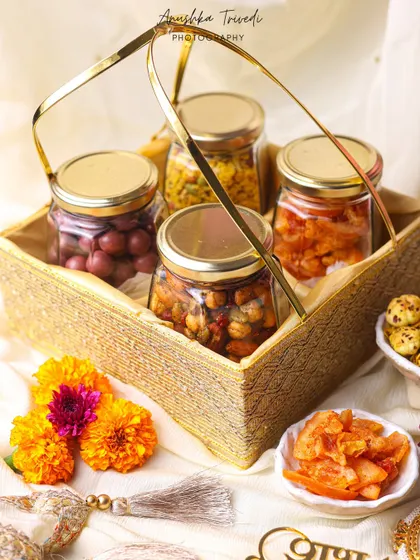 A rustic yet elegant hamper of assorted pickles and snacks, styled with marigold flowers for a traditional, homely feel.
