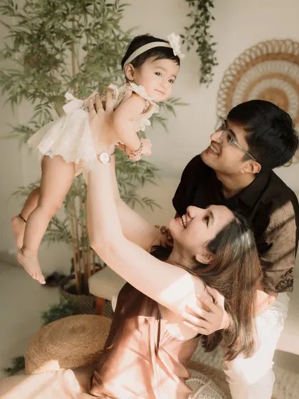 A dynamic shot of the family playing, with the daughter being lifted towards the ceiling.