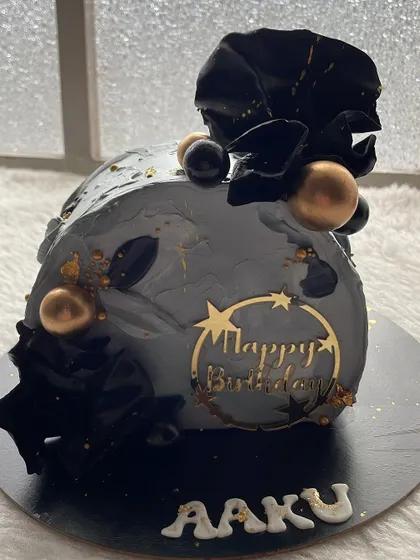 A moody and modern top-forward cake in shades of grey and black. The abstract design with gold accents is perfect for a sophisticated birthday.