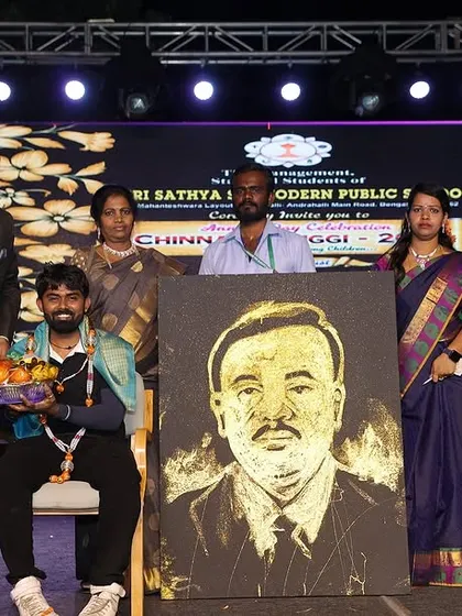 Being felicitated on stage after completing a live glitter portrait at a school event. It's a privilege to share my art with students and faculty.