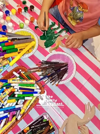A top-down view of the art and craft table, showing a child painting a wooden octopus. We provide all the supplies for a fun and mess-free creative session.