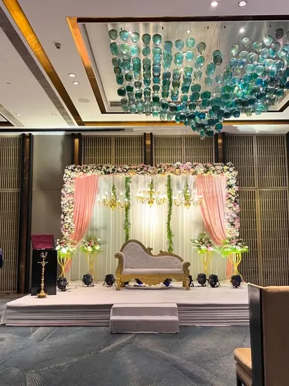 A wider view of the event hall and stage at Crowne Plaza. The decor is designed to complement the hotel's modern architecture and stunning ceiling installations.