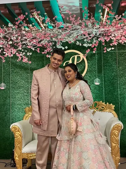 The happy couple posing against their beautiful stage backdrop.