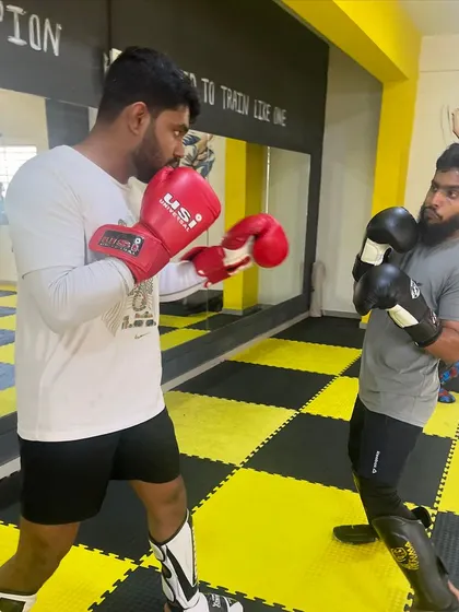 Two members engaged in a focused boxing sparring drill. This is where you learn to read your opponent and react in real-time.