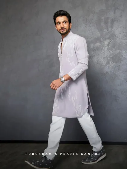 A full-body shot of Pratik Gandhi in the grey kurta set. The clean lines and modern embroidery make it a versatile piece for any stylish man.
