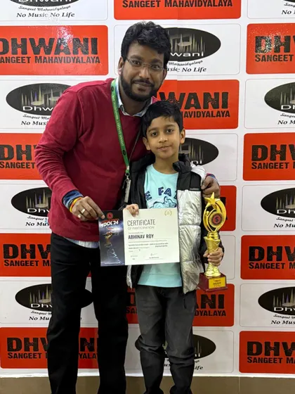 A proud teacher stands with our Radio Mirchi Spardha Idol winner. We provide dedicated mentorship to help our students excel in competitive environments.