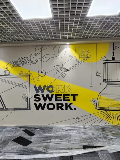 "Work Sweet Work." This modern doodle art in a Gurgaon office combines typography with whimsical illustrations of lightbulbs and perfume bottles, creating a clever and inspiring design.