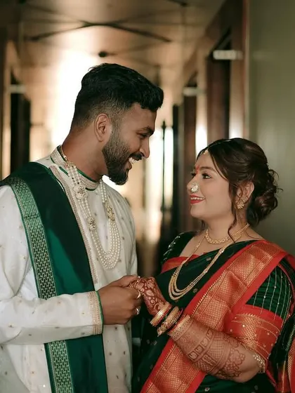 A candid, happy moment between the bride and groom in a hallway, sharing a look of love and excitement.