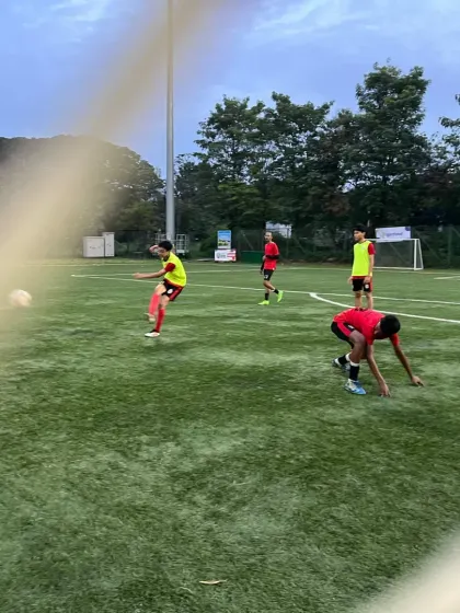 A player takes a shot on goal during a training session, captured through the netting.