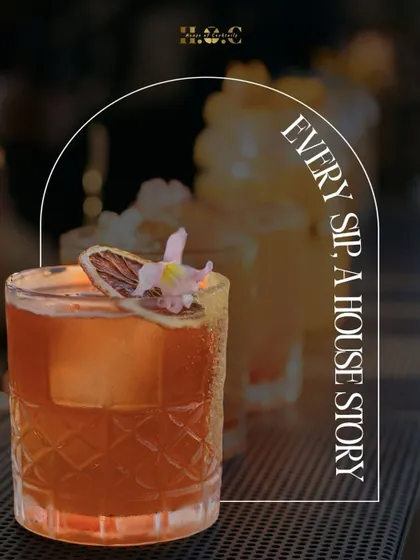 Every drink I make tells a story. This is a close-up of a signature cocktail, garnished with a dehydrated orange slice and an edible flower, served in a crystal-cut glass. It’s all about the details.