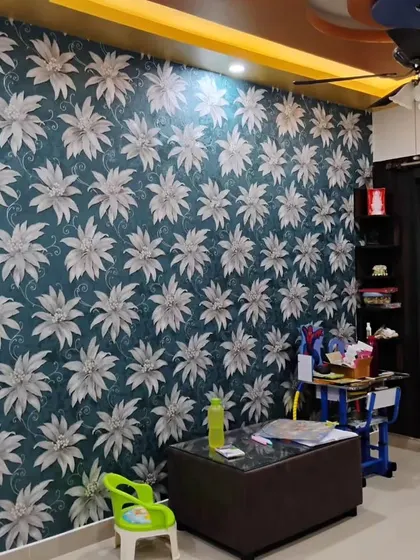 A living area with a large floral wallpaper in shades of grey and white on a dark background. The design is bold and sophisticated.