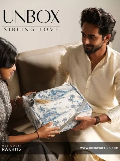 Unbox sibling love this Rakshabandhan. This image captures the beautiful moment of a sister gifting her brother a hamper with our signature blue and white toile-patterned box.