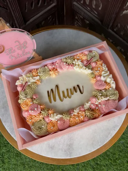 A vintage-style sheet cake for "Mum," decorated with intricate floral piping in pastel colors. These are great for serving a larger crowd.