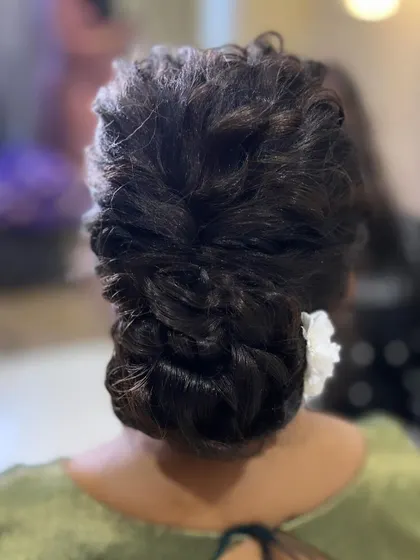 A back view of a voluminous messy bun. I use texturizing techniques to create this full, intricate look that is both modern and sophisticated.
