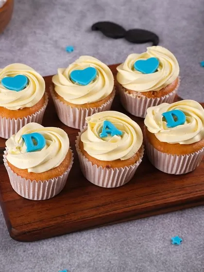 A set of our "I ❤️ DAD" cupcakes, perfect for showing your appreciation on Father's Day. Each vanilla cupcake is topped with cream cheese frosting and a custom blue heart.