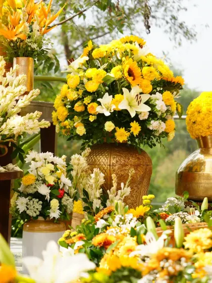 A sea of yellow and white flowers, including sunflowers, lilies, and tuberoses, creating a lush and abundant floral display.
