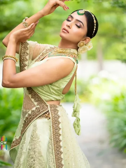 An artistic pose that highlights the graceful lines of the lehenga and the delicate hand jewelry. We guide our clients to create beautiful, expressive portraits.