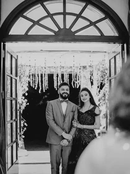 A black and white shot of the couple's grand entrance, seen from the perspective of their welcoming guests.
