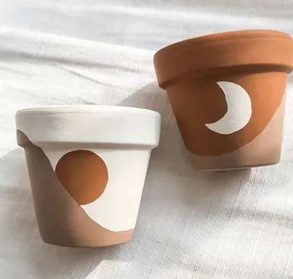 Sun and moon designs for your plant babies. These minimalist, hand-painted terracotta pots add a celestial touch to your indoor garden.