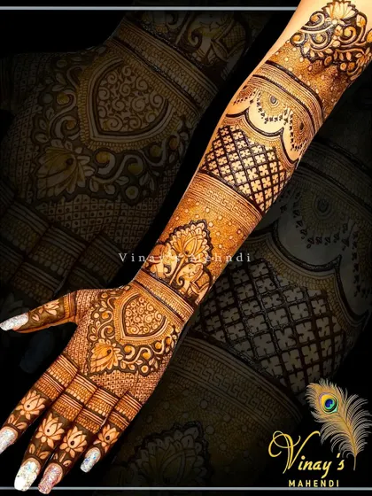 An elegant back-hand design with paisley and floral motifs. The intricate patterns on the fingers and wrist create a delicate, jewelry-like effect.