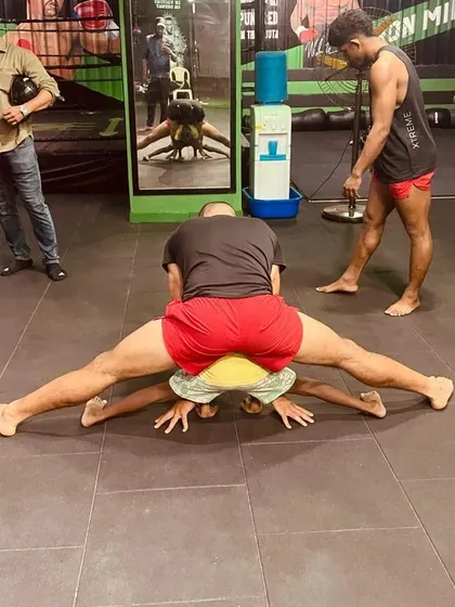 This is what building champions looks like. I am helping a young student with an advanced flexibility exercise. This level of discipline builds mental toughness as much as physical ability.