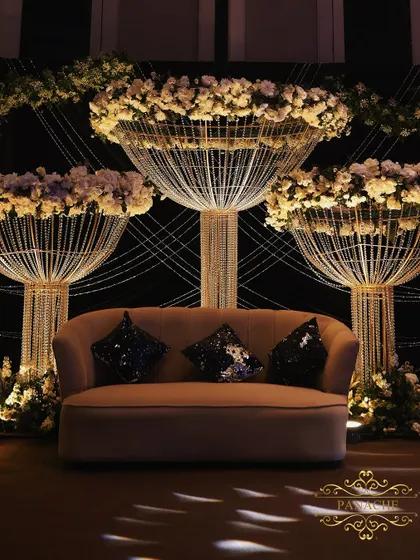 The stage setup for the Sangeet, featuring a comfortable lounge sofa against a backdrop of the stunning crystal and floral installations.