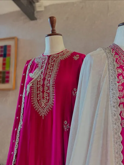 A stunning fuchsia suit by Jayanti Reddy, featuring intricate silver embroidery. The silhouette is classic and elegant, making it a timeless choice for the wedding season.