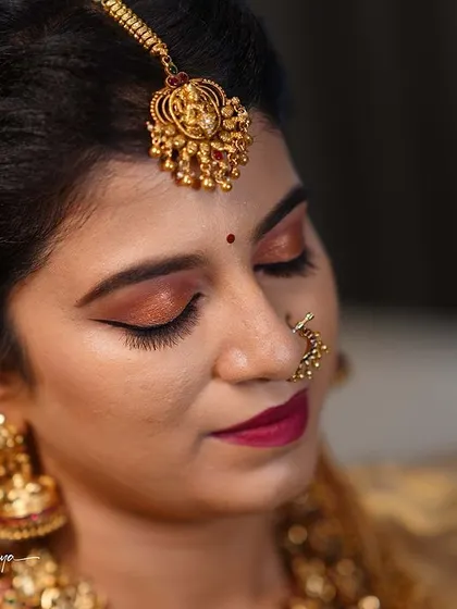 A close-up of Meghana's beautiful eye makeup, featuring a winged liner and warm, shimmery eyeshadow perfect for a traditional bridal look.