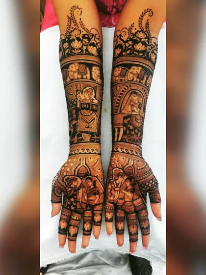 This design is rich with traditional imagery, including a wedding procession with elephants and a doli scene. The couple's portrait on the palms is the centerpiece of this elaborate bridal mehendi.
