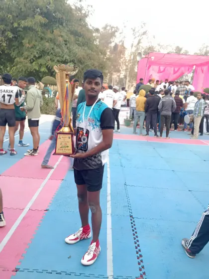 Another champion from our academy, holding the trophy high. We train our players to have the hunger to win.