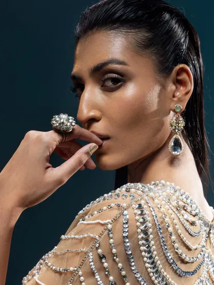 A close-up on a stunning piece of modern jewellery. The intricate design and beading of this shoulder and back accessory adds a unique, high-fashion element to the look.