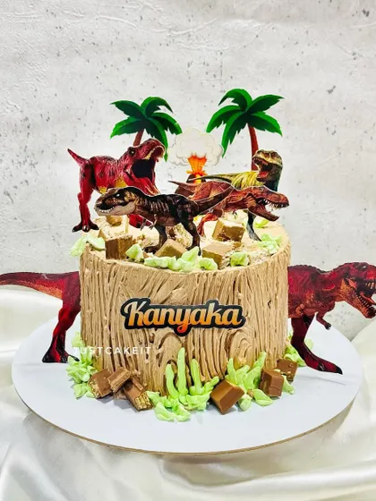 A thrilling dinosaur theme cake with a rustic, wood-like texture made from chocolate frosting. The cake is surrounded by fearsome dinosaurs, creating a prehistoric jungle scene.