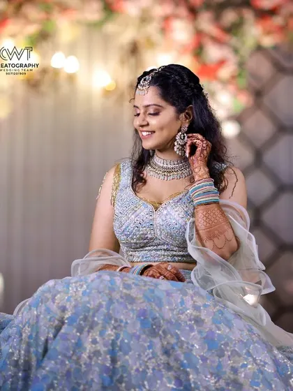 A beautiful candid shot of a woman in a sparkling lehenga, enjoying a moment at her Sangeet ceremony.