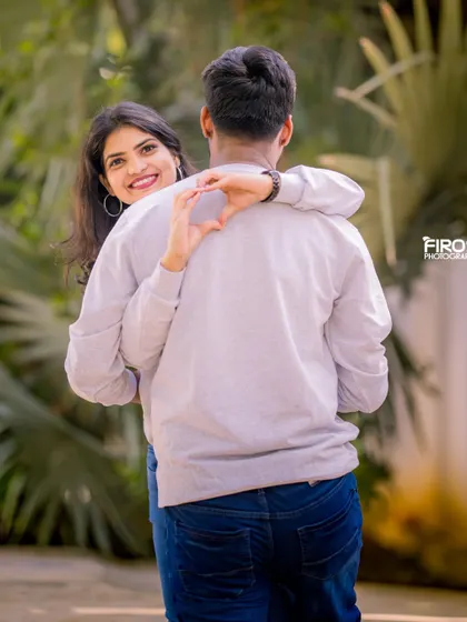 A playful and creative pose with a heart-shaped hand gesture. This is a fun way to show your love in a modern, casual pre-wedding shoot.