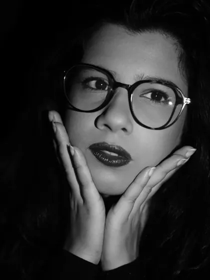 A playful yet thoughtful expression from the same black and white series. Experimenting with different moods within a single lighting setup adds range to a creative shoot.