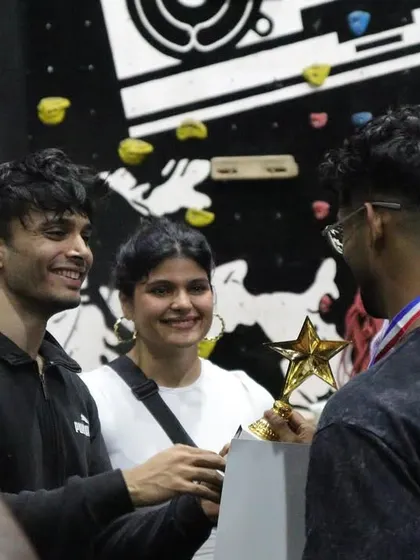The moment of victory. An athlete receives his trophy at THE OG BAR WARS #1, surrounded by fellow competitors and judges.