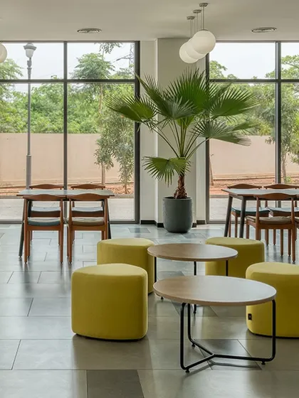 The cafeteria at Laurus Labs features floor-to-ceiling windows that look out onto a green landscape. We designed this space to be bright and airy, providing employees with a refreshing place to recharge.
