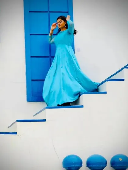 The sky blue satin gown looks stunning against this Santorini-themed backdrop. It's a versatile dress for pre-wedding shoots or elegant parties.
