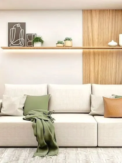 A minimalist living room with a white sofa and a simple floating shelf. The design emphasizes clean lines and a clutter-free environment.