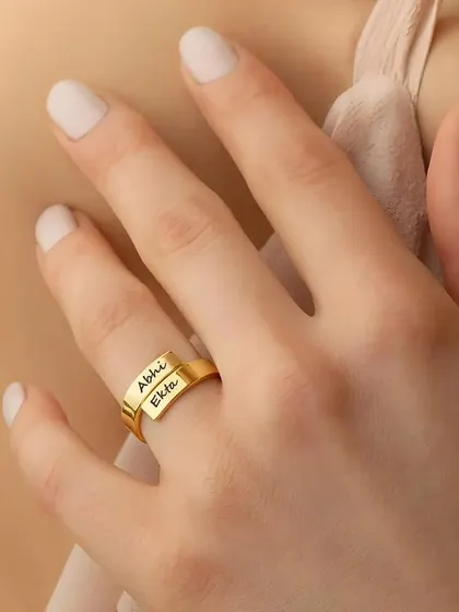 Our exclusive couple name ring, elegantly worn. This adjustable design allows for two names to be engraved on the overlapping bands, symbolizing your connection.