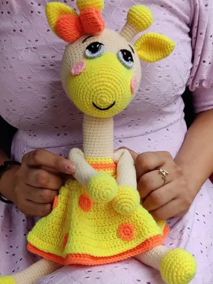 A customer holding her new giraffe doll, showing how it makes a perfect companion.