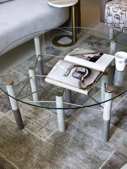 The Mystique Coffee Table is the embodiment of modern luxury. Its sleek glass top rests on a series of cylindrical legs with a unique two-tone finish, creating an impression that is both airy and architectural.