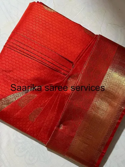 A classic red silk saree, folded and ready for storage. It will remain crease-free until you are ready to wear it.