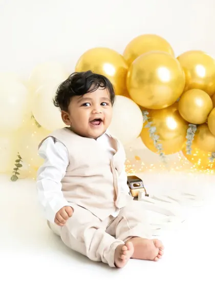 Look at that happy, chubby face! This is what pure joy looks like. A simple setup with celebratory gold balloons is all you need to capture a beautiful milestone moment.