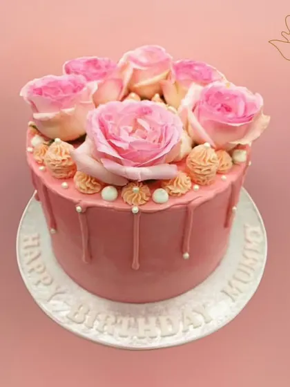 A beautiful floral delight crafted with love for a special mother's birthday. This charming pink drip cake is topped with fresh pink roses, making it as special as she is.