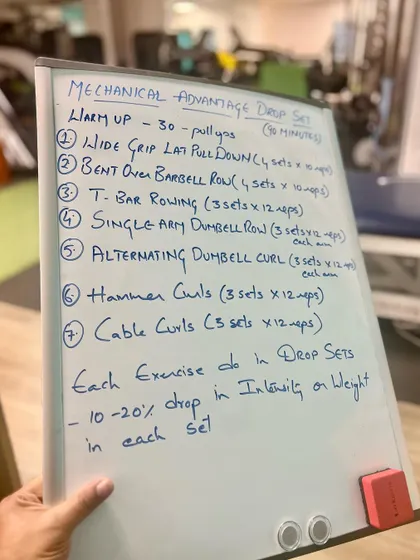 A look at a "Mechanical Advantage Drop Set" workout plan written on our whiteboard. We design structured, science-based programs to help our clients achieve their strength goals.
