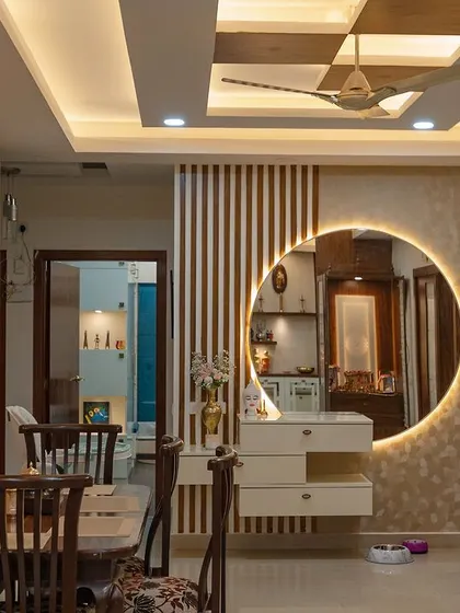 This dining space features a striking circular mirror with backlighting that serves as a stunning focal point. The design is both modern and glamorous.