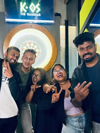 This squad is all about the peace signs and good times. A group of friends celebrating a fun night of karaoke and darts.