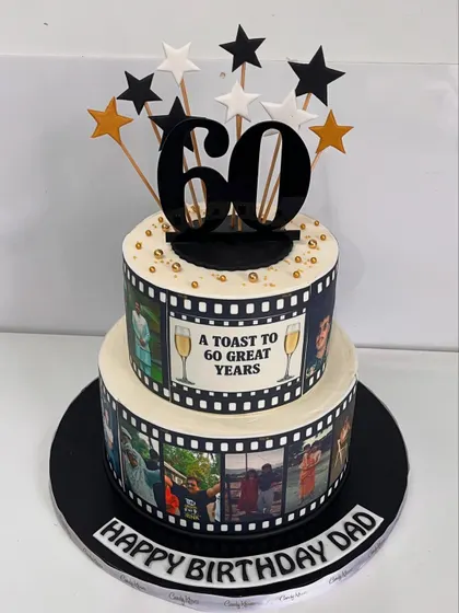 A cinematic celebration for a dad's 60th. This two-tiered cake is designed like a film reel, featuring edible photo strips of cherished memories.