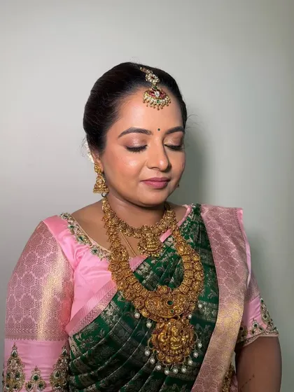 A close-up of a classic South Indian bridal makeup look. I used soft pink and gold tones on the eyes to match her saree, paired with a flawless base that looks like second skin.